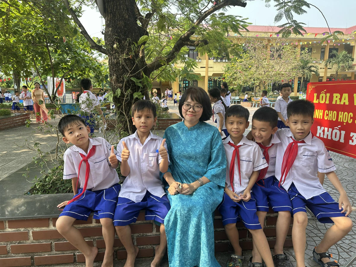 Nhà thơ Huỳnh Mai Liên với các em học sinh ở Đồng Hới. Ảnh: NVCC.