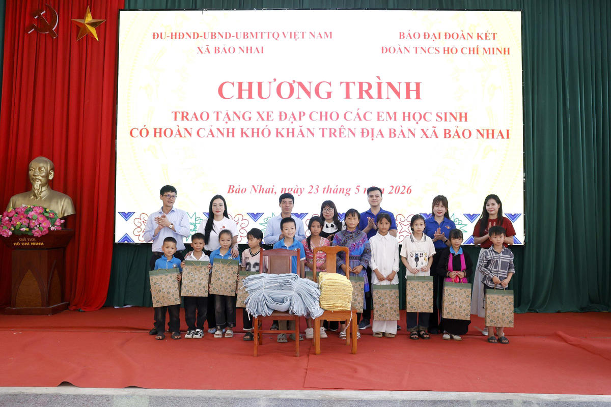 Các đại biểu tặng quà cho các em học sinh có hoàn cảnh khó khăn. Ảnh: Quang Vinh.