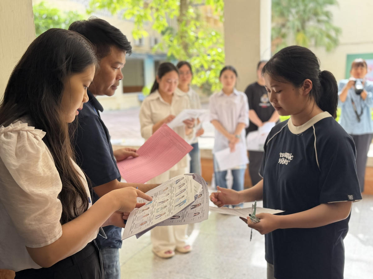 Cán bộ coi thi kiểm tra thông tin thí sinh trước khi vào phòng thi.