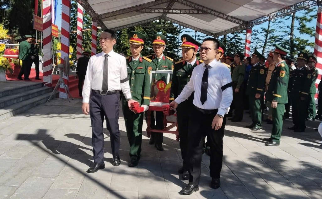 Chủ tịch UBND tỉnh Hà Tĩnh Phan Thiên Định cùng đại diện tỉnh Bolikhamxay (Lào) di chuyển hài cốt liệt sĩ đến an táng tại các phần mộ. Ảnh: TM.