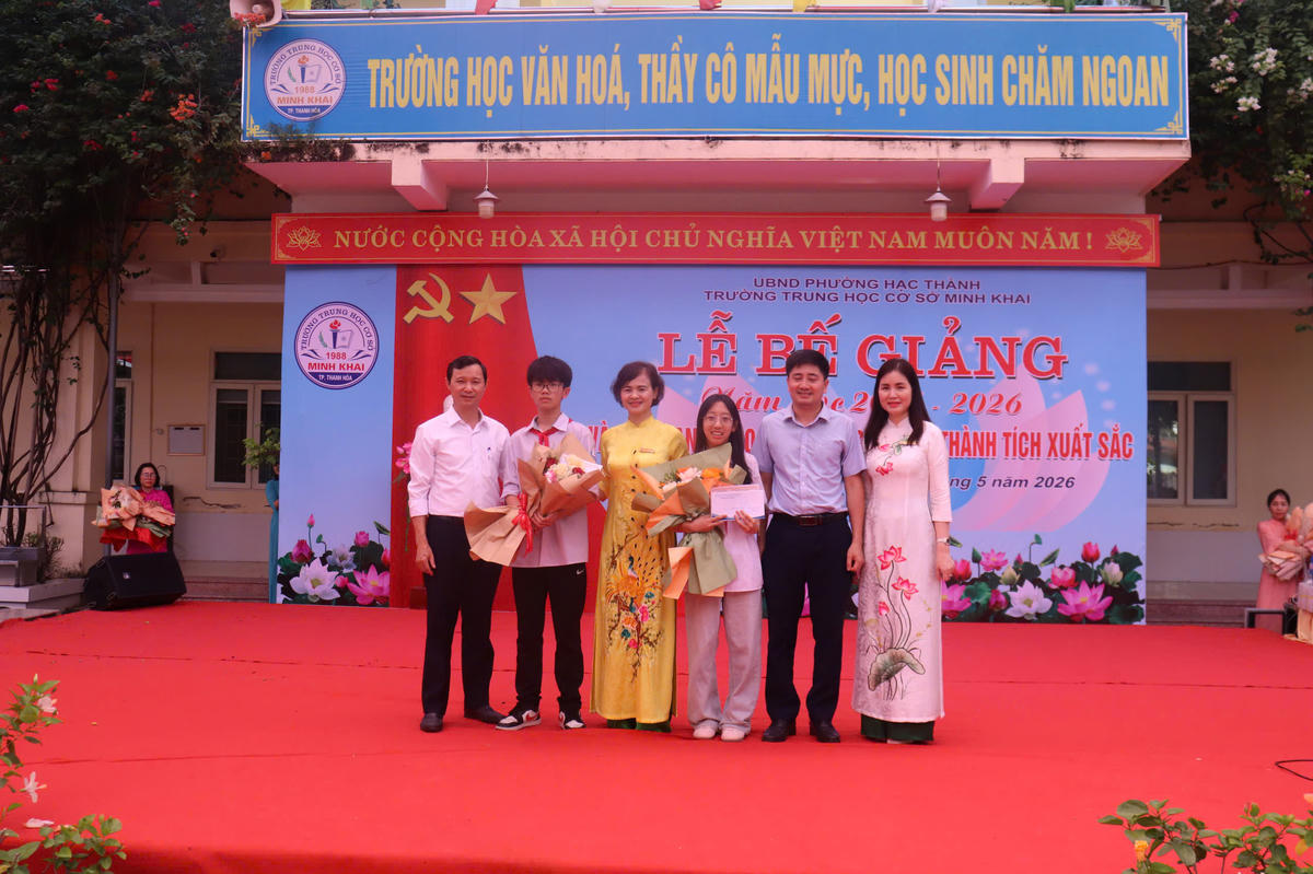 Lãnh đạo Trường THCS Minh Khai, đại diện hội phụ huynh chúc mừng HS Trịnh Chí Bảo và Nguyễn Khuê Anh, lớp 8A5 đạt giải Nhì kỳ thi giao lưu học sinh giỏi cấp phường năm học 2025-2026. Ảnh: Đình Minh. 