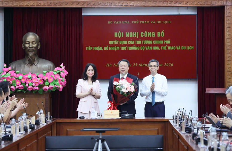 Bộ trưởng Bộ VHTT&DL tặng hoa chúc mừng ông Nguyễn Huy Dũng - Ảnh: Thu Giang