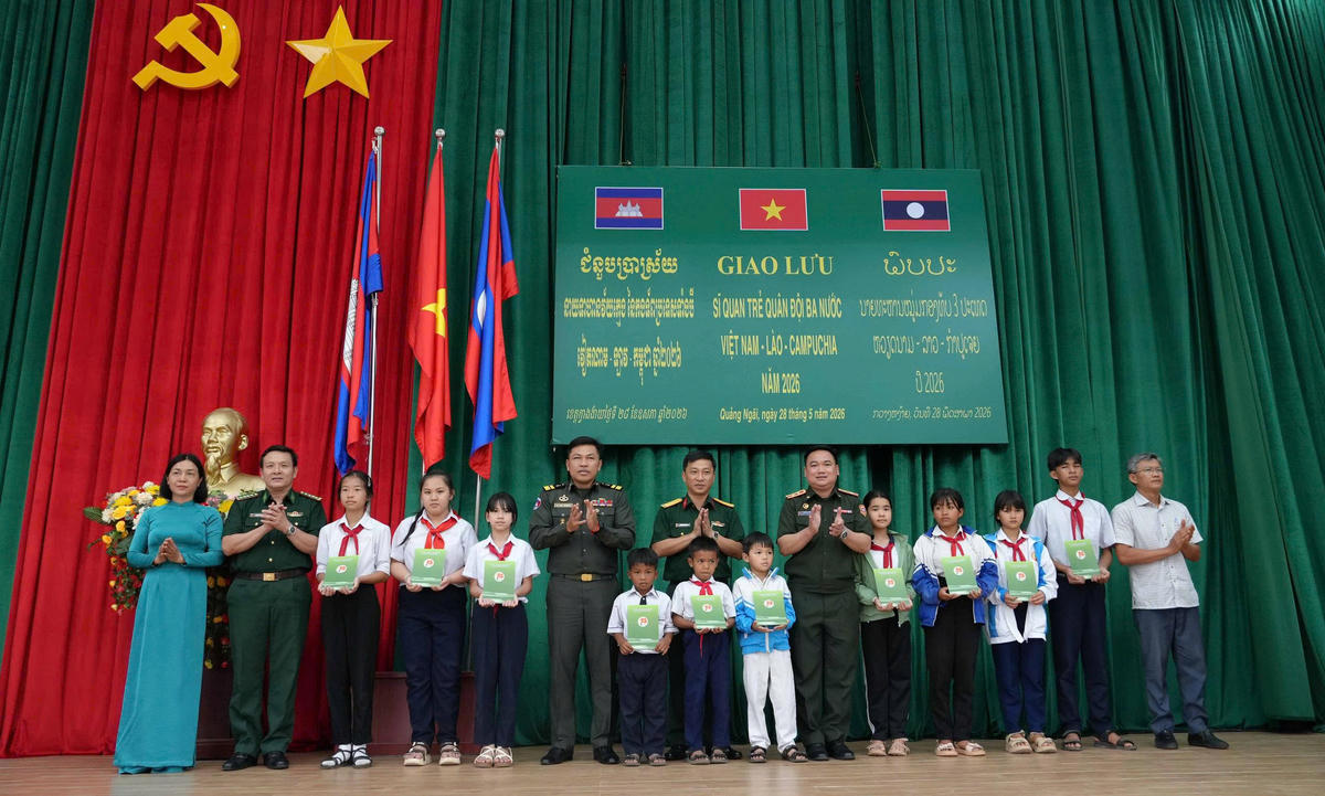 Đoàn sĩ quan Việt Nam-Lào-Campuchia tặng quà cho các học sinh xã Bờ Y, tỉnh Quảng Ngãi. Ảnh: TT.