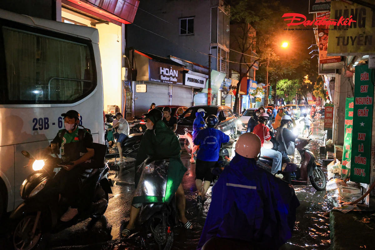 Hà Nội mưa lớn, người dân bì bõm lội nước trở về nhà