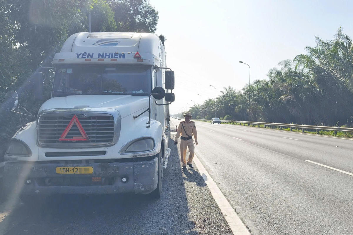 Lực lượng CSGT Đội đường bộ số 11 kiểm tra, xử lý tài xế xe đầu kéo dừng trên làn khẩn cấp nhưng không đặt thiết bị cảnh báo theo quy định trên đại lộ Thăng Long.