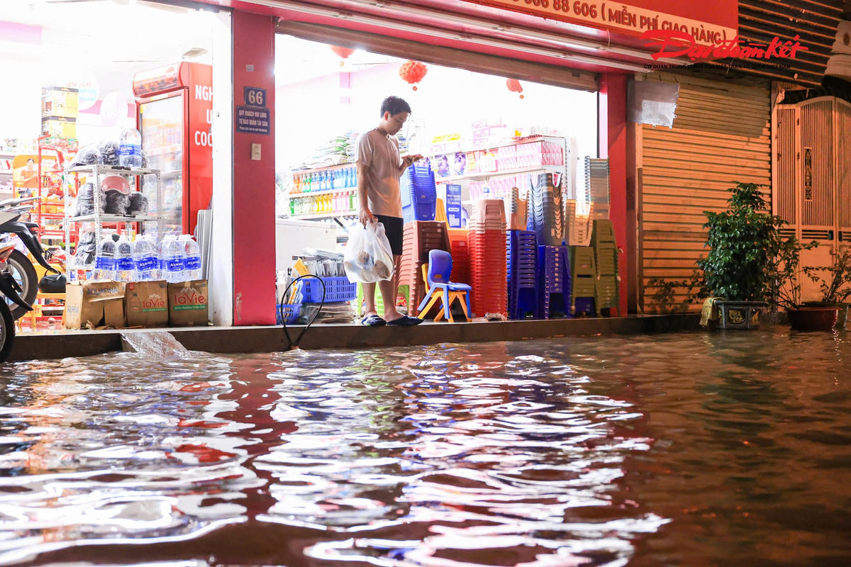 Hà Nội mưa lớn, người dân bì bõm lội nước trở về nhà