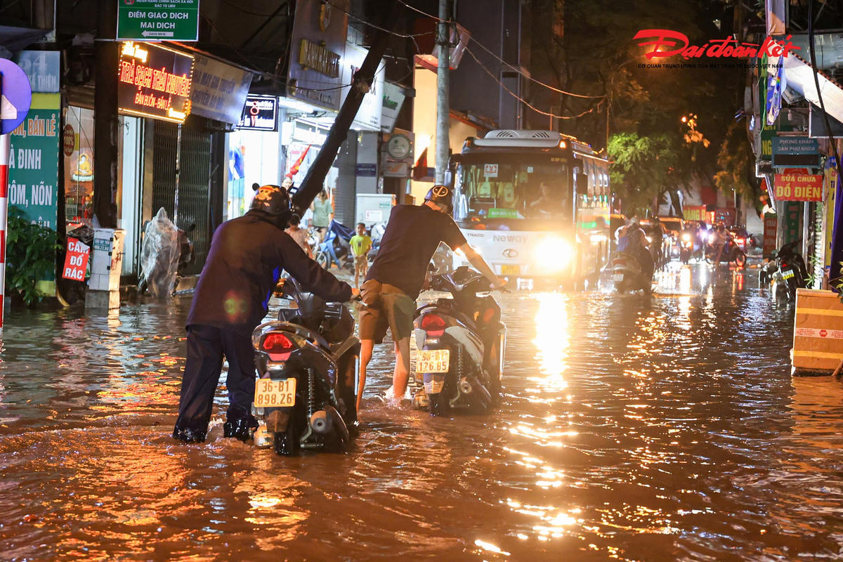 Hà Nội mưa lớn, người dân bì bõm lội nước trở về nhà