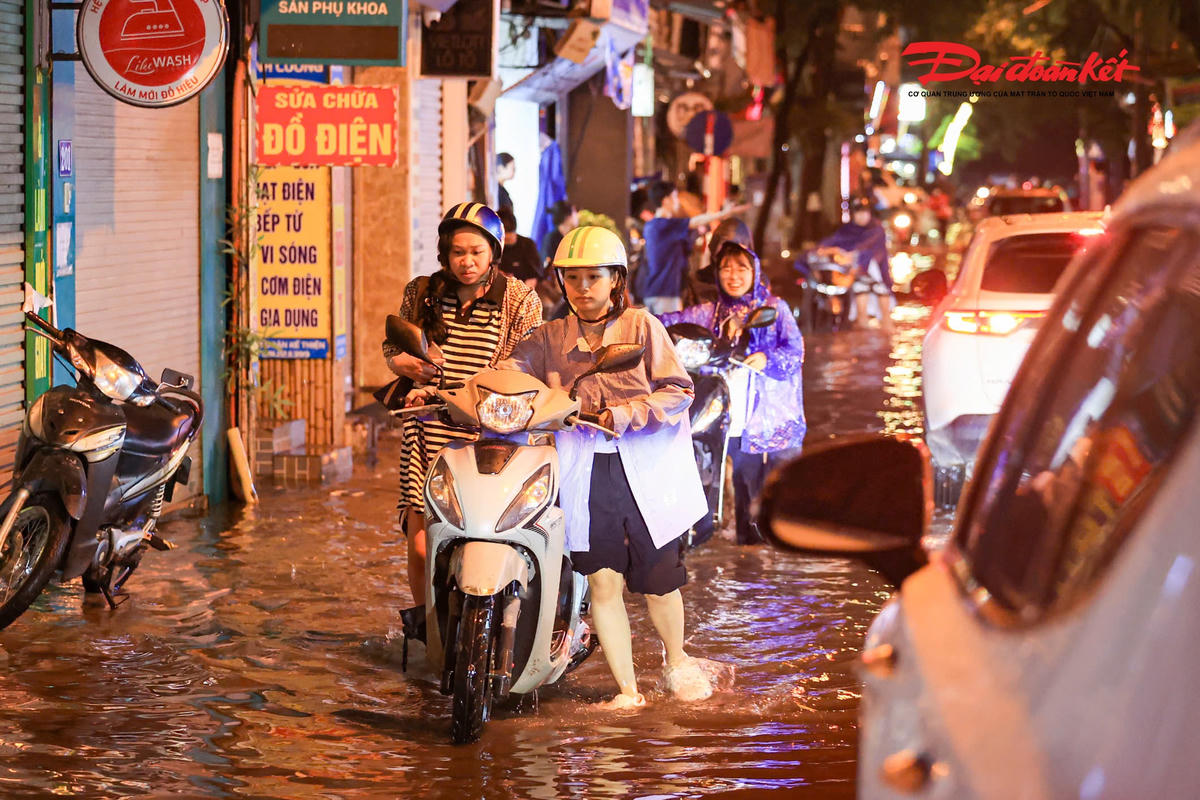 Hà Nội mưa lớn, người dân bì bõm lội nước trở về nhà