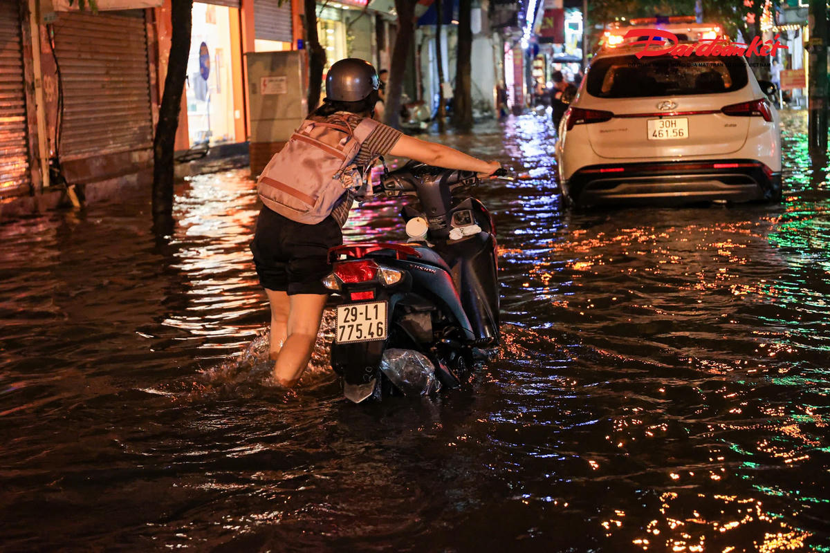 Hà Nội mưa lớn, người dân bì bõm lội nước trở về nhà
