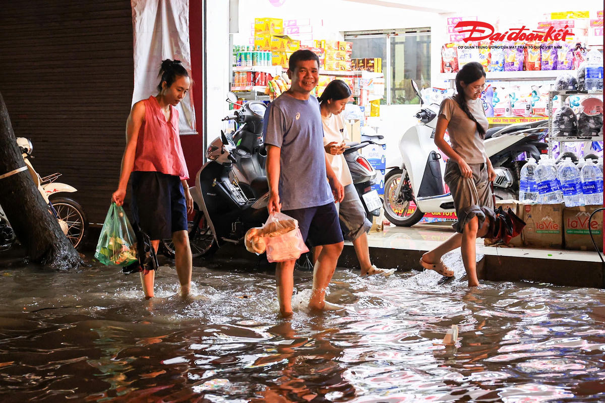 Hà Nội mưa lớn, người dân bì bõm lội nước trở về nhà