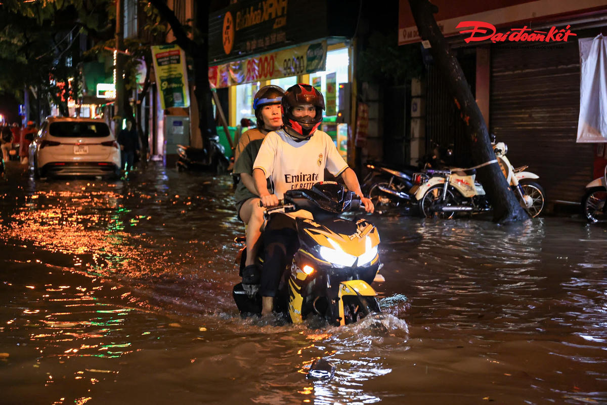 Hà Nội mưa lớn, người dân bì bõm lội nước trở về nhà
