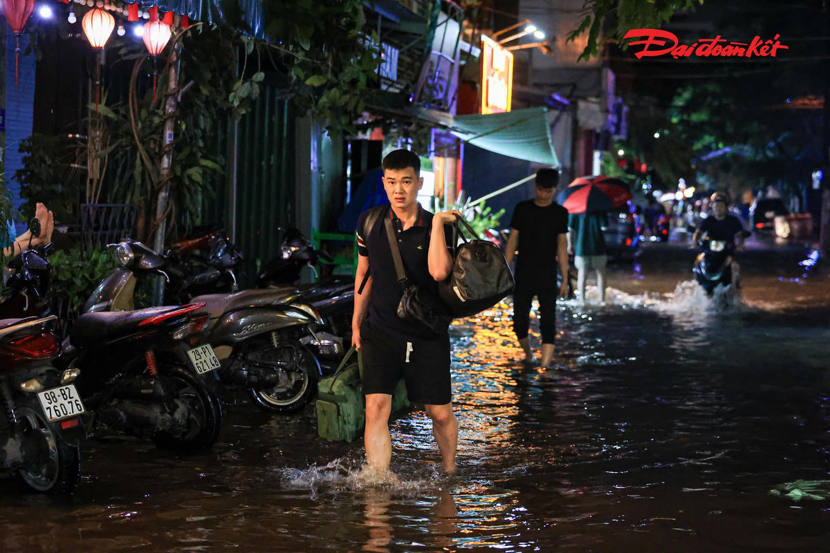 Hà Nội mưa lớn, người dân bì bõm lội nước trở về nhà
