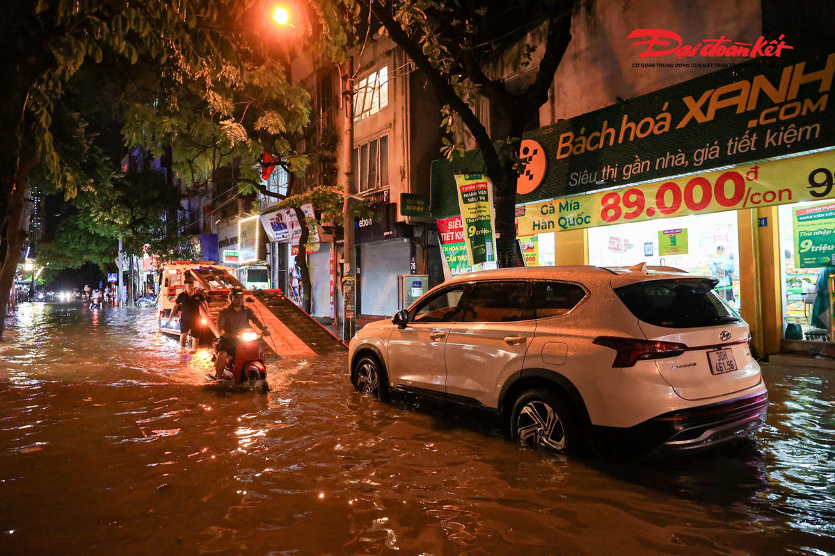 Hà Nội mưa lớn, người dân bì bõm lội nước trở về nhà