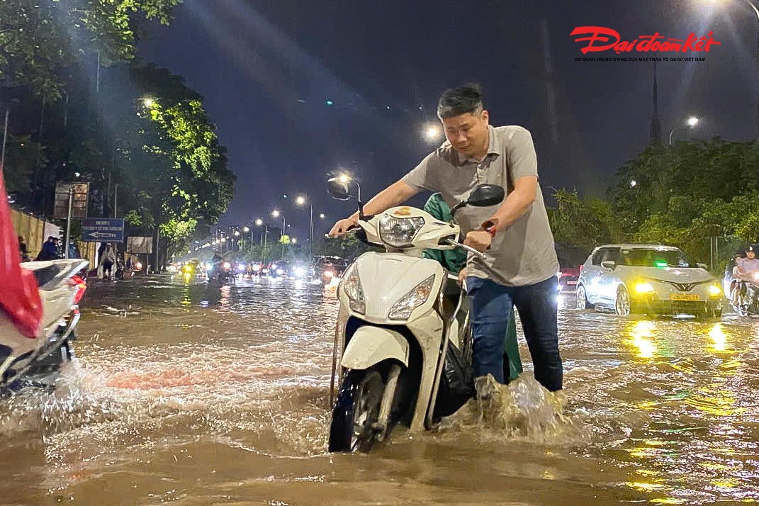 Hà Nội mưa lớn, người dân bì bõm lội nước trở về nhà