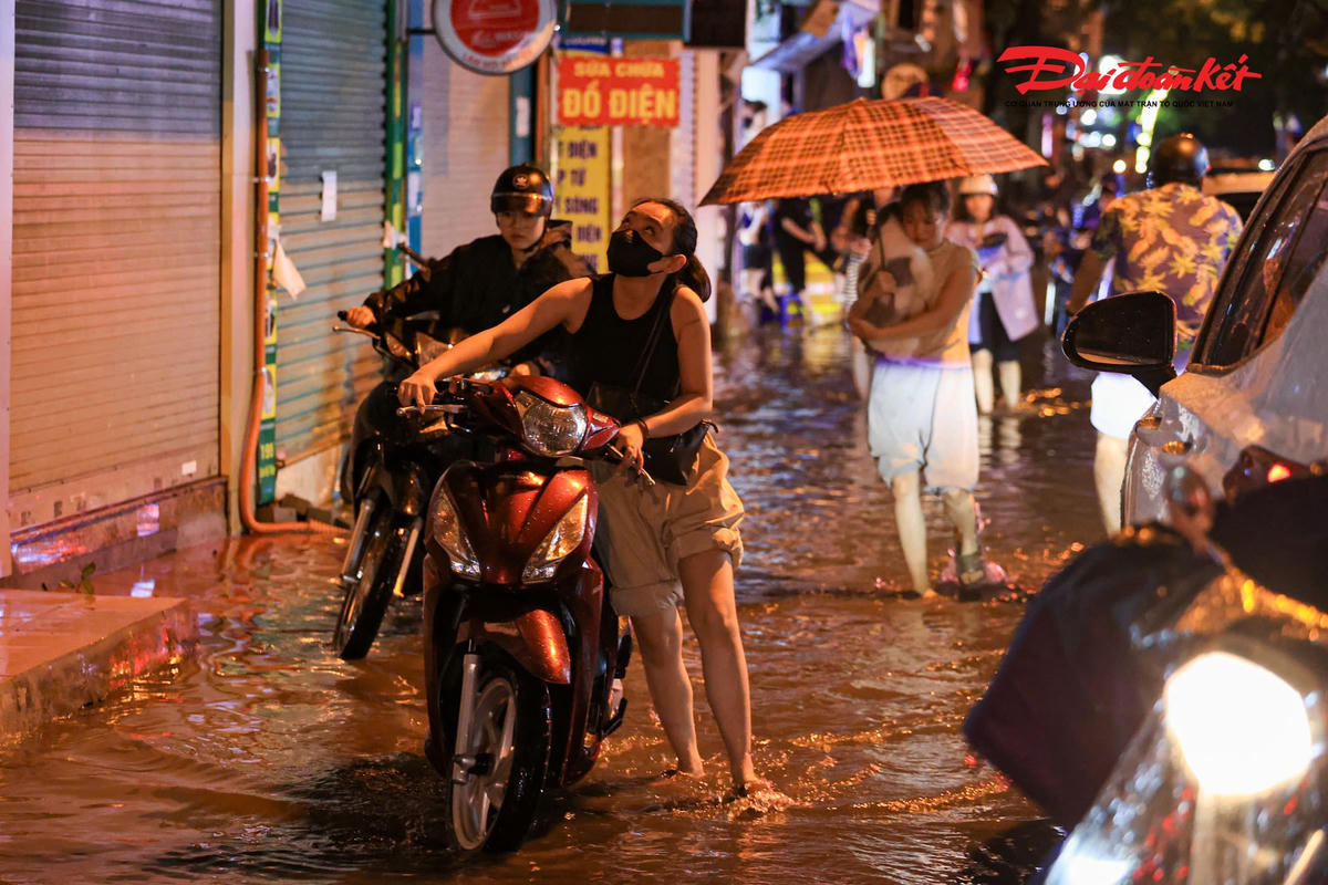 Hà Nội mưa lớn, người dân bì bõm lội nước trở về nhà