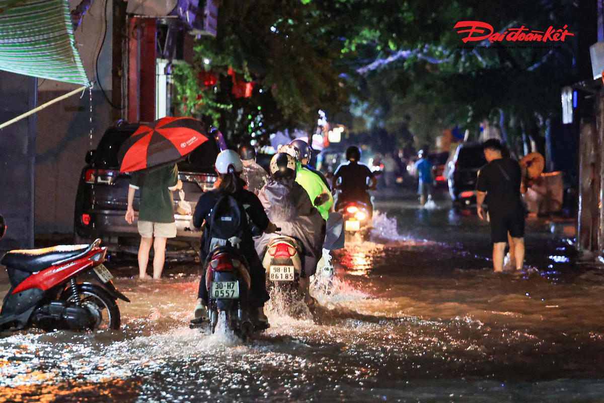 Hà Nội mưa lớn, người dân bì bõm lội nước trở về nhà