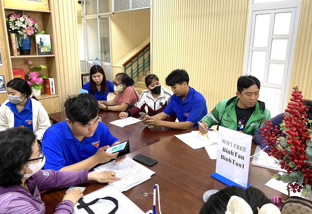 Các đoàn viên thanh niên phường Bình Tân hướng dẫn thủ tục online cho người dân. Ảnh Q.Đ.
