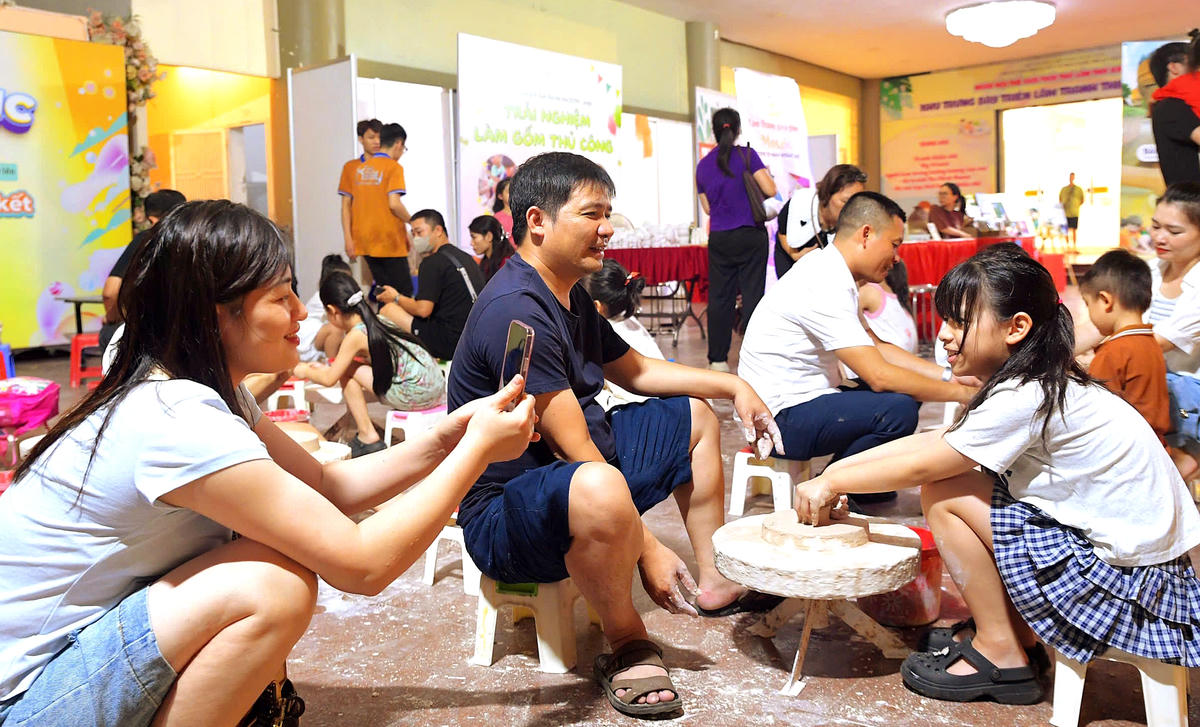Em nhỏ cùng bố mẹ lưu giữ khoảnh khắc trải nghiệm làm gốm tại chương trình.