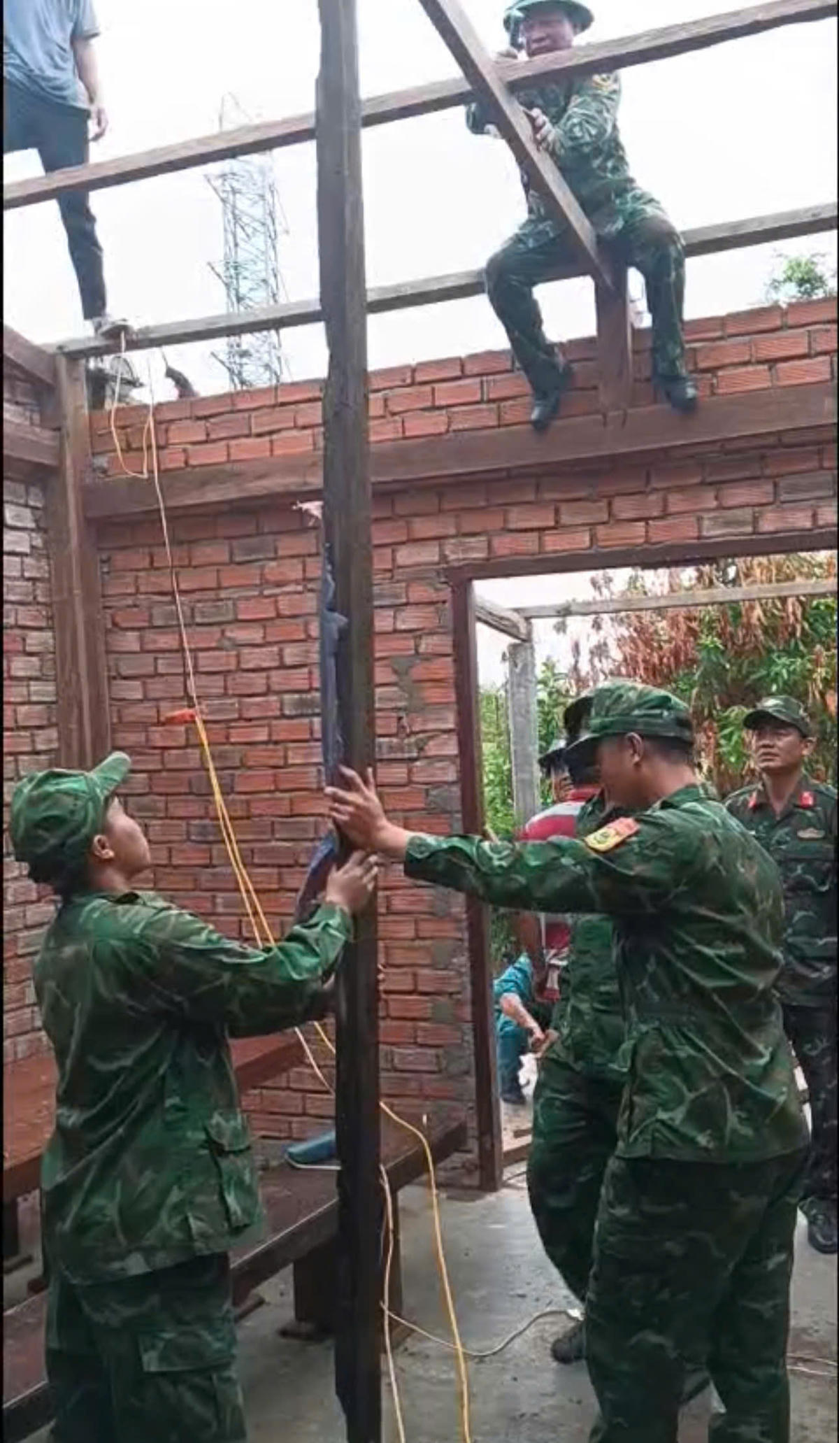 Cán bộ, chiến sĩ Đồn Biên phòng 735 (Bộ đội Biên phòng Đắk Lắk) đang dựng lại mái nhà tạm cho dân&nbsp;Ảnh: BP.