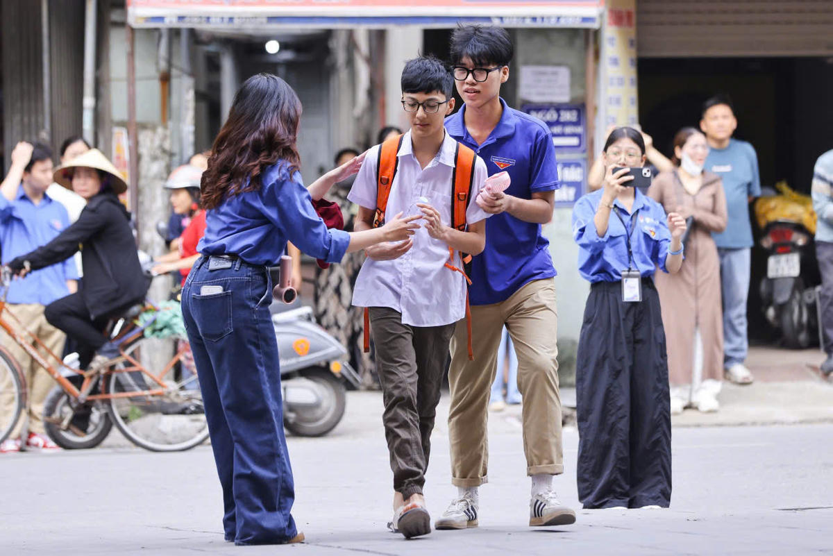Từ 6h sáng, các tình nguyện viên tại điểm thi Trường THPT Nguyễn Trãi đã có mặt để hướng dẫn, hỗ trợ thí sinh dự thi. Ảnh: Quang Vinh.