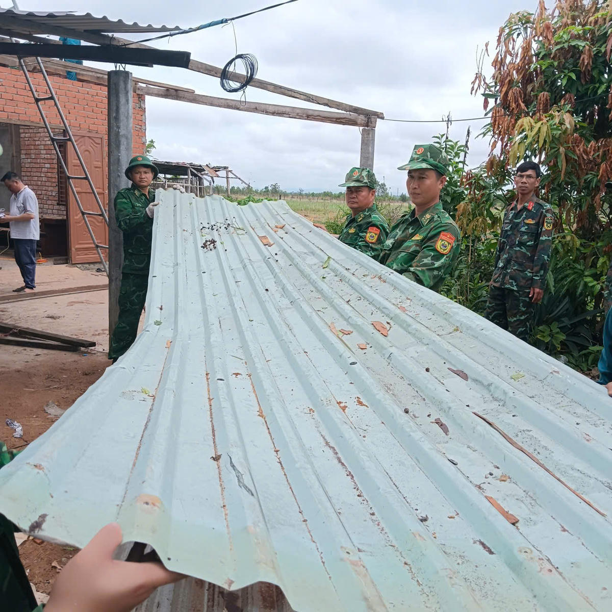 Cán bộ, chiến sĩ Đồn Biên phòng 735 (Bộ đội Biên phòng Đắk Lắk) đang&nbsp;giúp dân khắc phục hậu quả sâu giông lốc. Ảnh: BP.