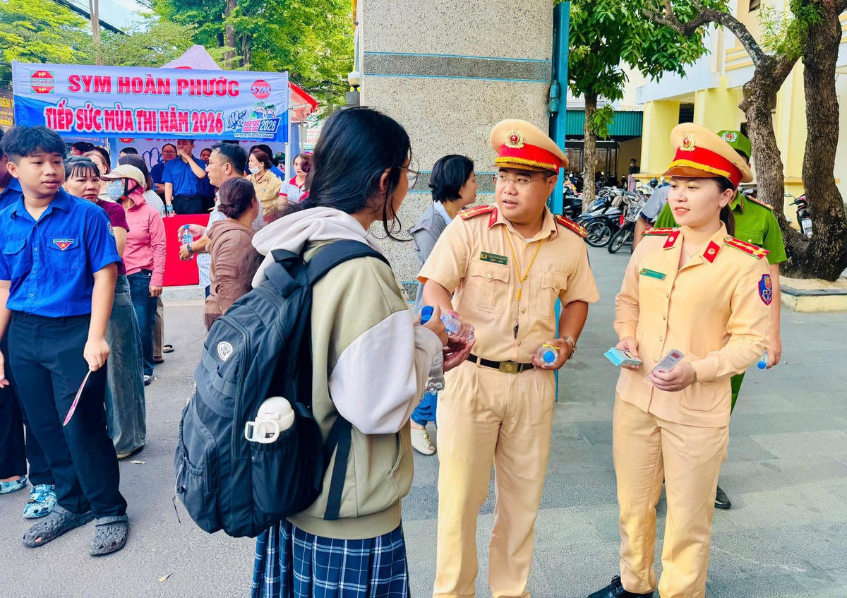 Lực lượng cảnh sát giao thông tỉnh Quảng Ngãi tiếp nước cho thí sinh tại điểm thi. Ảnh: CS.