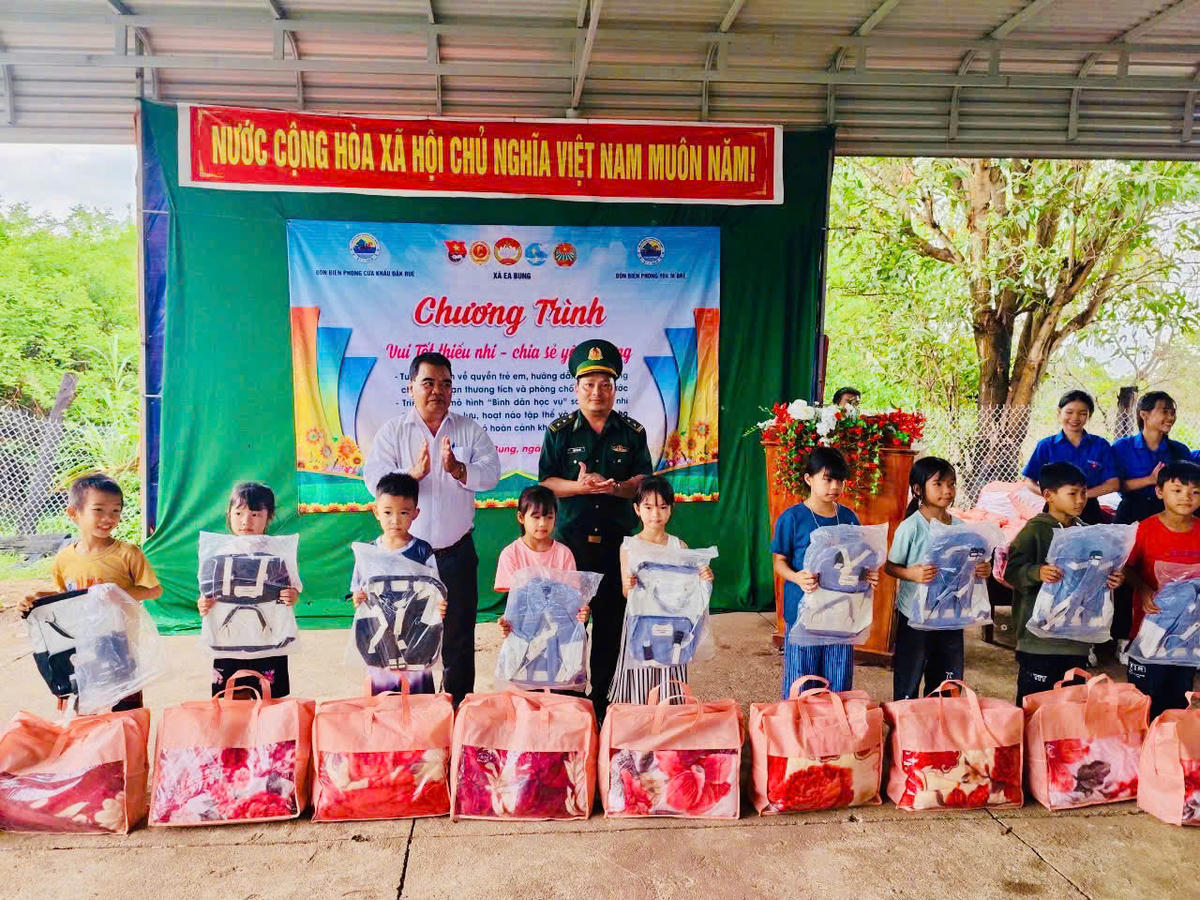 Trung tá Phạm Văn Ban, Chính trị viên phó Đồn Biên phòng Yok M'Bre và đại diện chính quyền địa phương tặng quà cho các cháu thiếu nhi thôn 14, xã Ea Bung. Ảnh: BP.