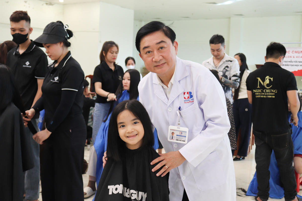 ThS.BS Nguyễn Viết Bình - Phó Giám đốc Bệnh viện Ung bướu Nghệ An chụp ảnh lưu niệm cùng người tham gia hiến tóc tại chương trình "Trạm tóc ước mơ" năm 2026. Ảnh: PT
