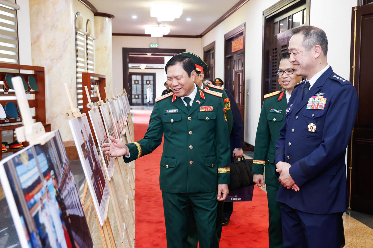 Đại tướng Nguyễn Tân Cương và Đại tướng Uchikura Hiroaki tham quan trưng bày triển lãm ảnh về quan hệ giữa hai nước. Ảnh: Quang Vinh