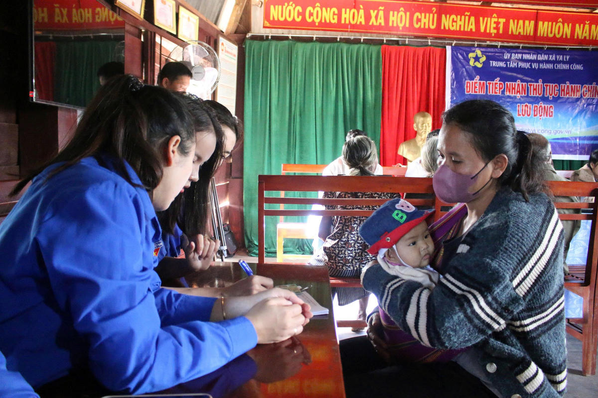 Cán bộ xã vùng cao Quảng Ngãi hướng dẫn người dân làm thủ tục hành chính tại địa phương. Ảnh: BT.