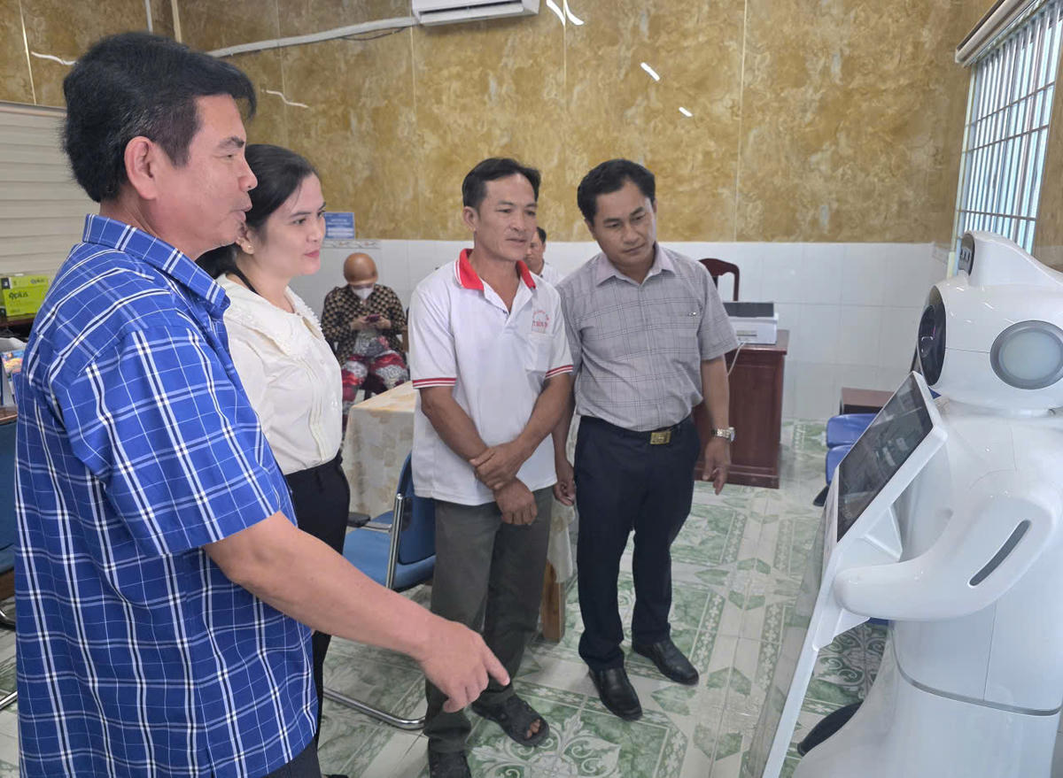 Công chức Trung tâm Phục vụ hành chính công xã Vĩnh Phước hỗ trợ người dân lấy số thực hiện thủ tục hành chính. Ảnh: Nguyên Du