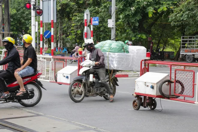 Đèn tín hiệu đã bật nhưng người dân vẫn cố tình vượt qua rào chắn đường sắt.&nbsp;