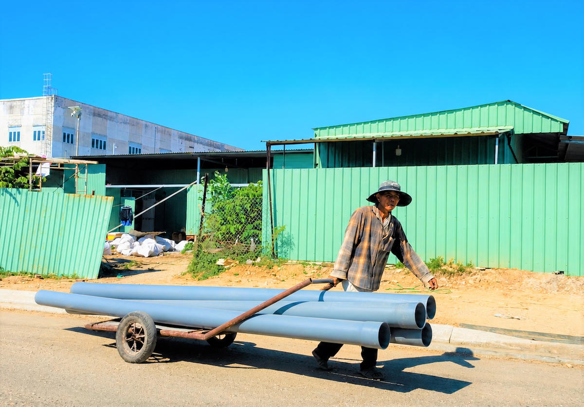 Công nhân vận chuyển vật liệu thi công dự án. Ảnh: TT.
