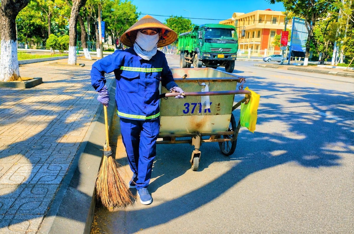 Chị Dương Thị Thủy đang dọn vệ sinh trên đường Trần Phú. Ảnh: TT.