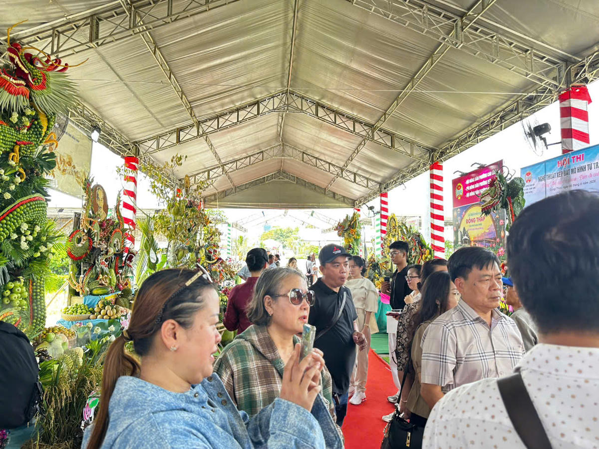 Từng dòng người đổ về quảng trường tham quan, chụp ảnh và tìm hiểu các hoạt động của lễ hội. Nhiều gian hàng trưng bày các loại trái cây đặc trưng của Đồng Tháp và khu vực Đồng bằng sông Cửu Long thu hút sự quan tâm của người dân, du khách ngay từ những giờ đầu mở cửa. (Ảnh: Trung Ngãi).