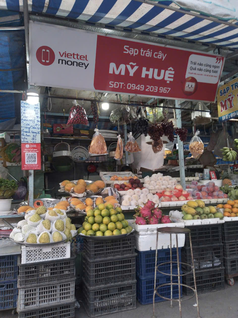Nhiều tiểu thương ở các chợ truyền thống cũng dần thích ứng bằng việc treo mã QR giúp khách hàng thanh toán không dùng tiền mặt. (Ảnh: Trung Ngãi).