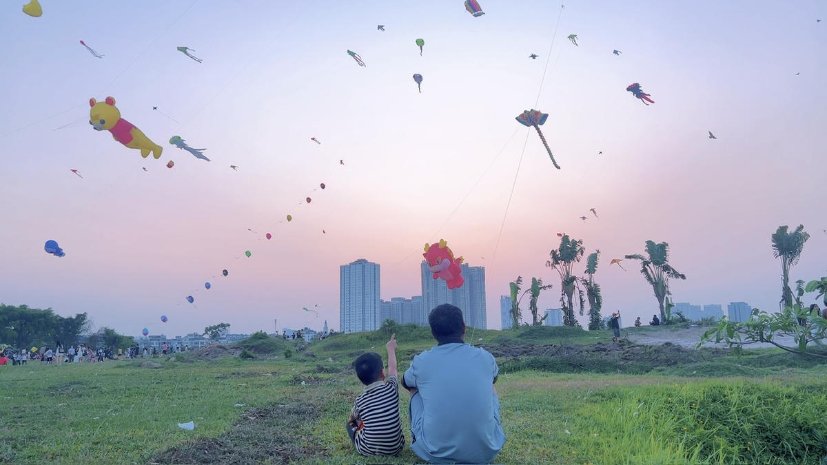 Hai bố con anh Tiến cùng thả diều và ngắm nhìn bầu trời.