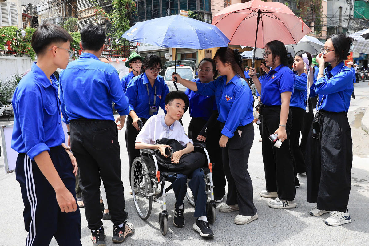Tại điểm thi có thí sinh đặc biệt được các tình nguyện viên hỗ trợ vào phòng thi.