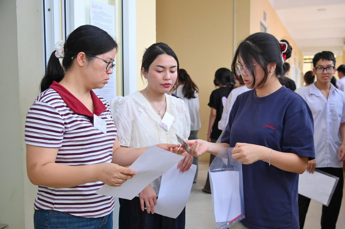Cán bộ coi thi kiểm tra thông tin thí sinh trước khi vào phòng thi.