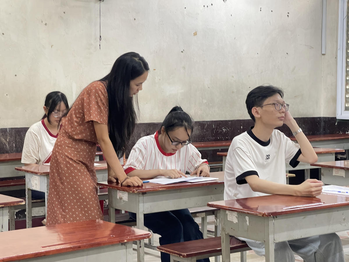 Các thí sinh đối chiếu thông tin cá nhân, số báo danh lần cuối trước khi bắt đầu kỳ thi. Ảnh: Đ.Xá.