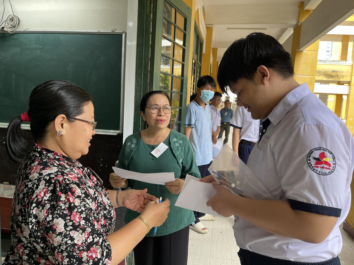 Các giám thị làm thủ tục vào phòng thi với các thí sinh. Ảnh: Đ.Xá.