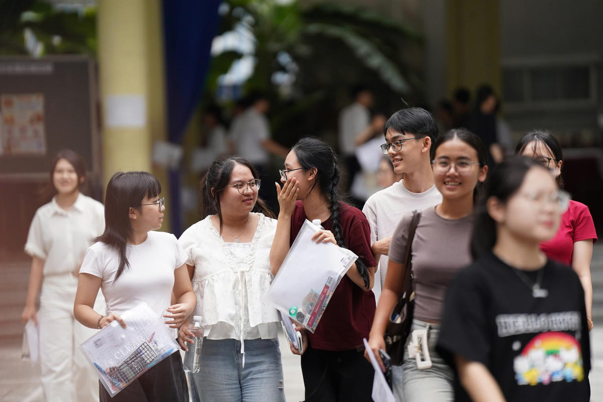 Các thí sinh trao đổi bài thi sau khi kết thúc môn thi Ngữ văn. Ảnh: CĐ.
