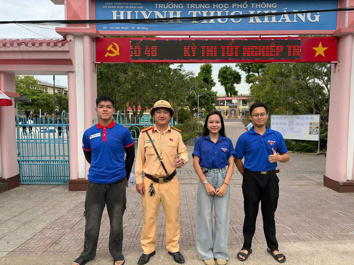 Lực lượng CSGT, Công an TP Đà Nẵng cùng tình nguyện viên trực phân luồng điều tiết giao thông trước điểm thi. Ảnh: CĐ.