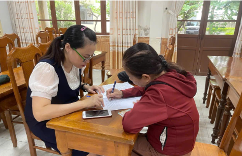 Chuyên viên BHXH cơ sở Điện Bàn hướng dẫn người dân chuyển sang nhận lương hưu qua tài khoản ATM
