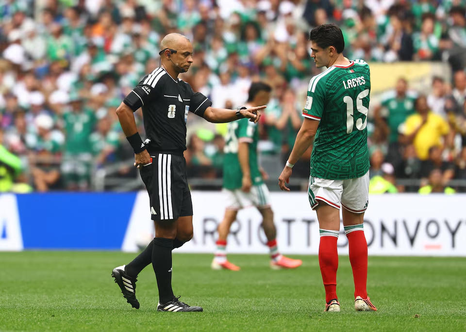 Trọng tài Wilton Sampaio đi ngang qua Israel Reyes của Mexico khi ông với tay rút thẻ đỏ để đuổi Themba Zwane của Nam Phi ra khỏi sân. Nguồn: Reuters.
