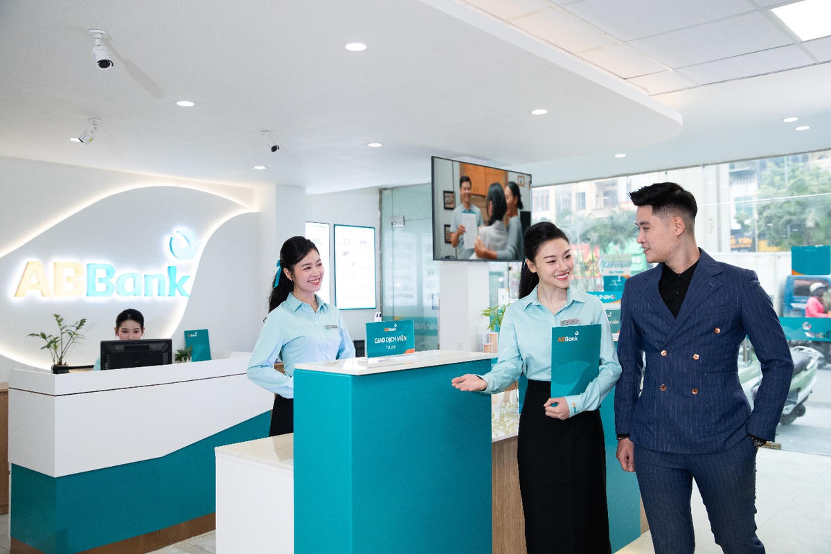The image depicts a modern banking environment with ABBank's branding, featuring a counter with two assistants, a teller, and various logos and branding elements.

AI-generated content may be incorrect.