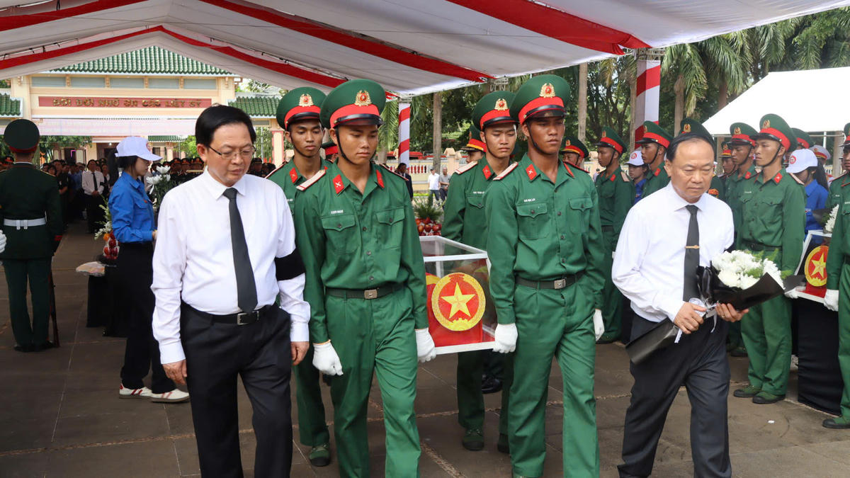 Phó Thủ tướng Hồ Quốc Dũng (bên trái) tiễn đưa và an táng các hài cốt liệt sĩ. Ảnh: CĐ.