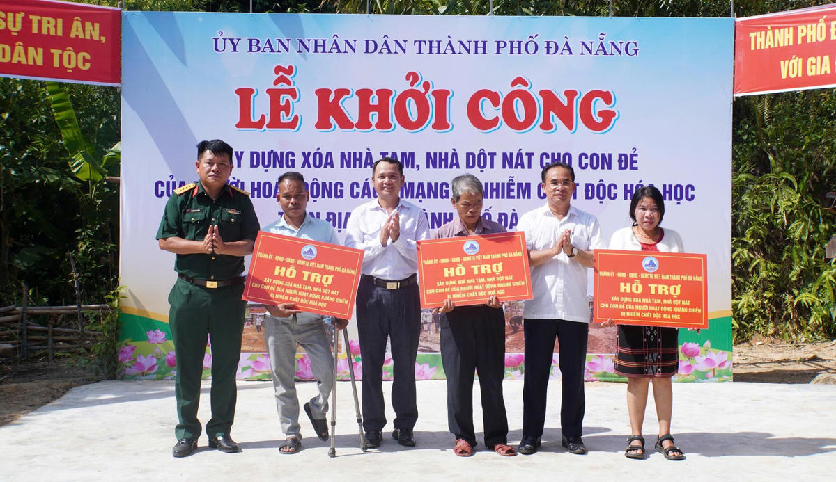 Lãnh đạo UBND TP Đà Nẵng trao biển tưởng trưng hỗ trợ xây nhà cho con nạn nhân chất độc da cam. Ảnh: QS.