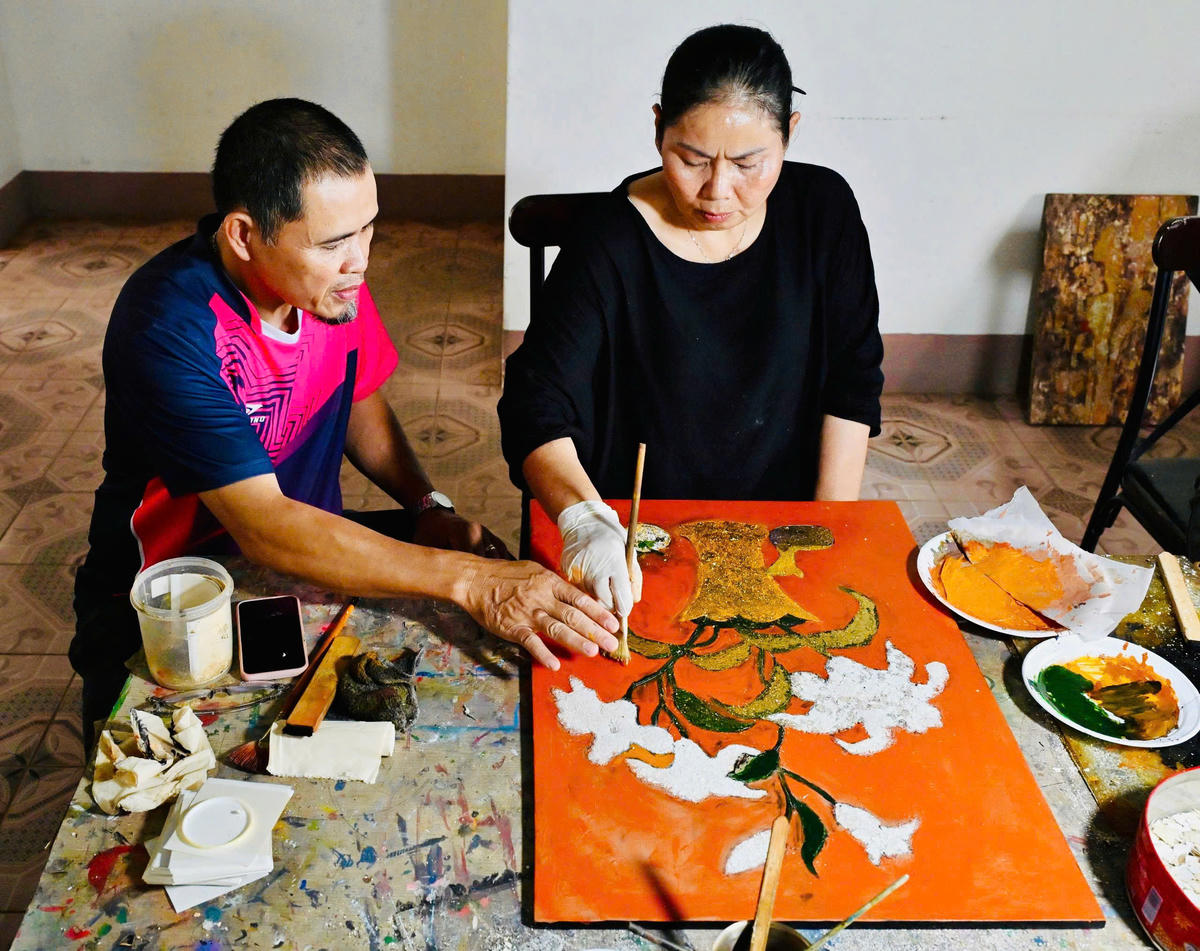 Họa sĩ Trương Văn Linh đang hướng dẫn cho họa sĩ nữ vẽ tranh sơn mài.