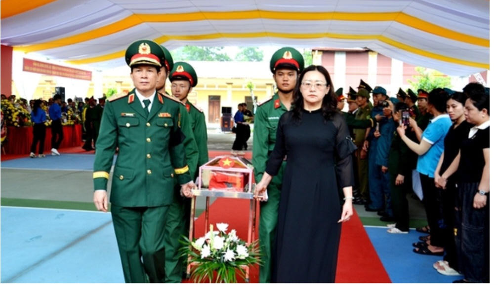 Bà Giàng Thị Dung - Phó Bí thư Tỉnh ủy, Trưởng đoàn đại biểu Quốc hội tỉnh Lào Cai cùng các đại biểu di chuyển hài cốt liệt sĩ đến an táng tại Nghĩa trang liệt sĩ Bản Qua, xã Bát Xát, tỉnh Lào Cai. Ảnh: Quốc Hồng.